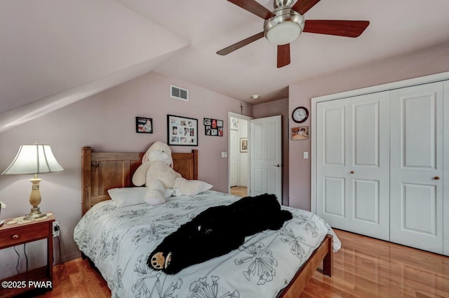 bedroom with visible vents, a closet, ceiling fan, light wood-type flooring, and vaulted ceiling