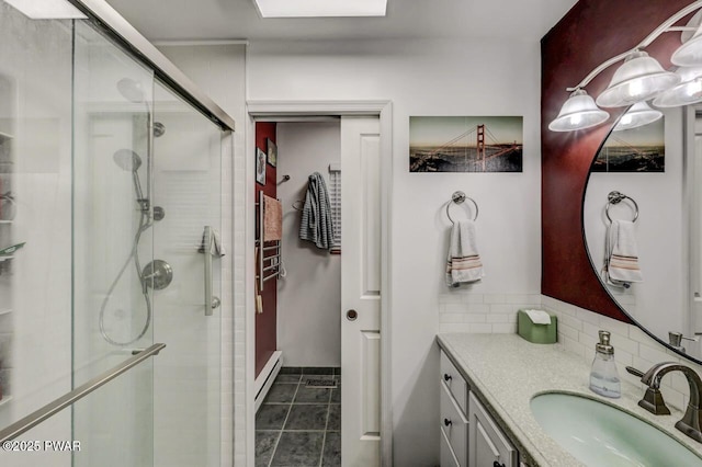 bathroom with a shower stall, tasteful backsplash, vanity, baseboard heating, and tile patterned floors