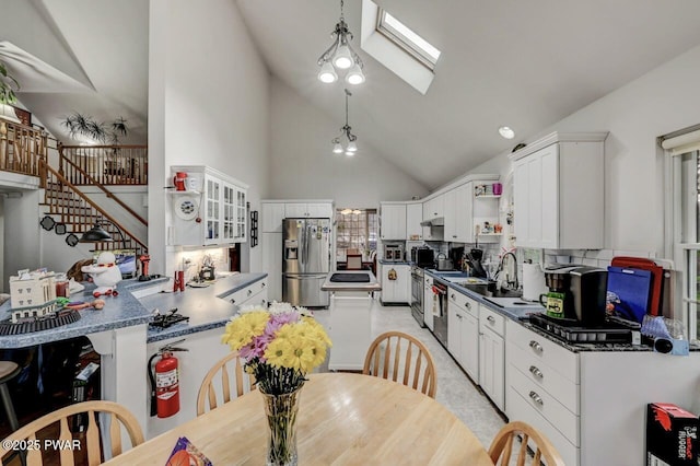 kitchen featuring stainless steel fridge with ice dispenser, open shelves, dark countertops, white cabinets, and a skylight