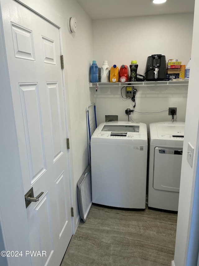 laundry area with wood-type flooring and separate washer and dryer