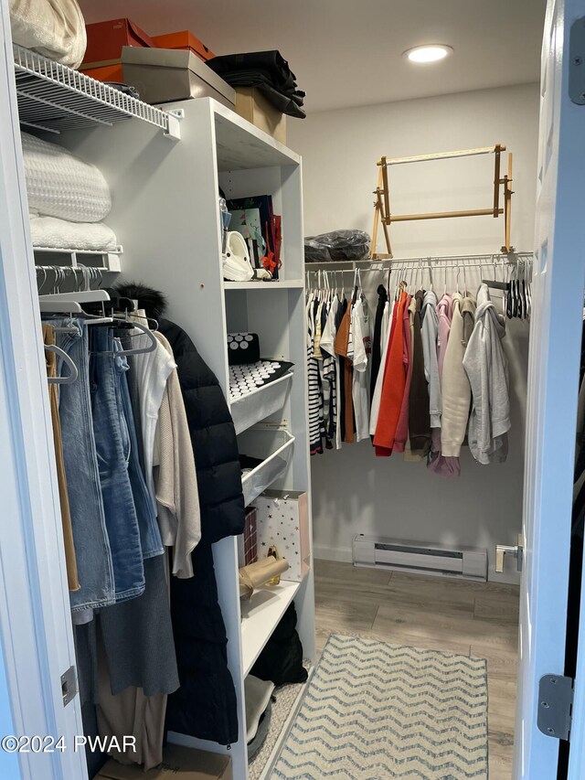 walk in closet with light wood-type flooring and a baseboard radiator