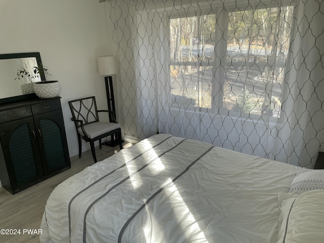 bedroom with multiple windows and light hardwood / wood-style floors