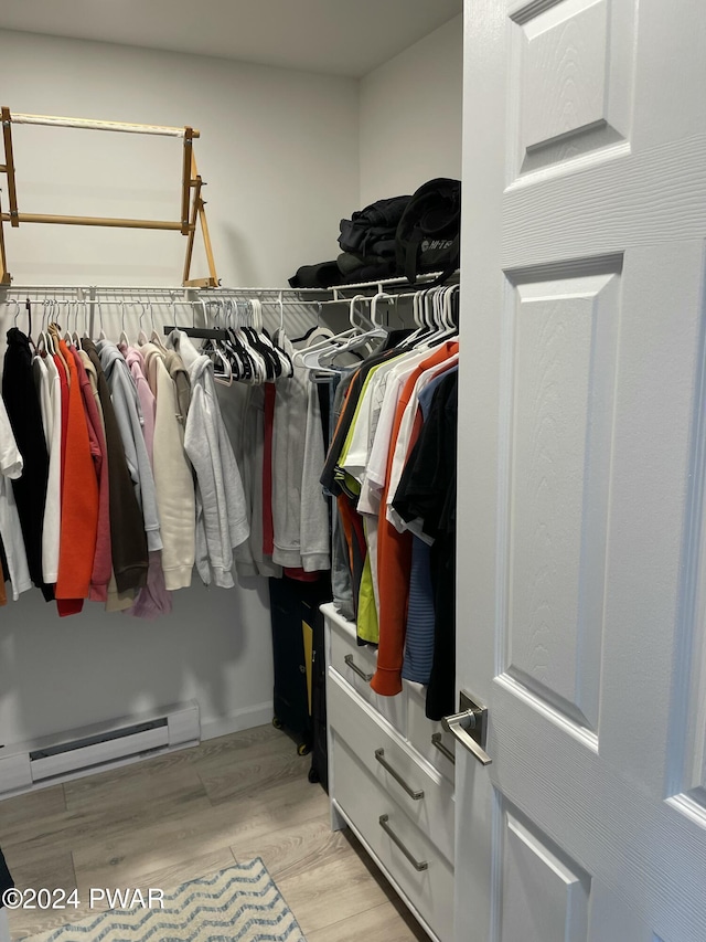 walk in closet featuring light hardwood / wood-style floors and a baseboard heating unit