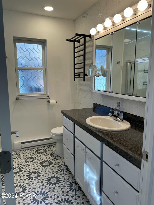 bathroom with vanity, tile patterned flooring, baseboard heating, walk in shower, and tasteful backsplash