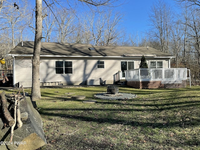 back of property featuring a yard and a wooden deck