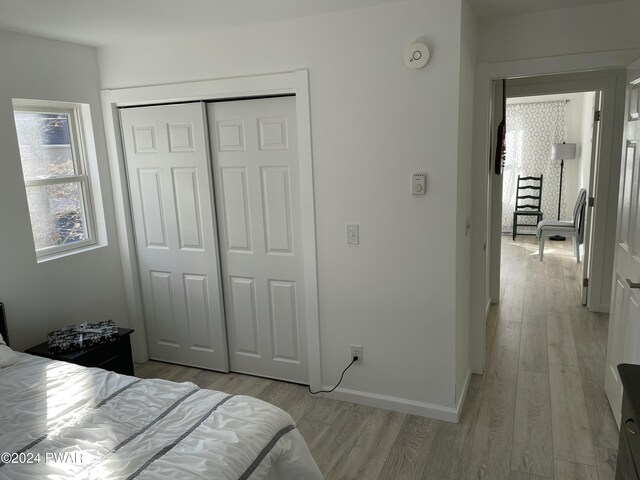 bedroom with light wood-type flooring and a closet