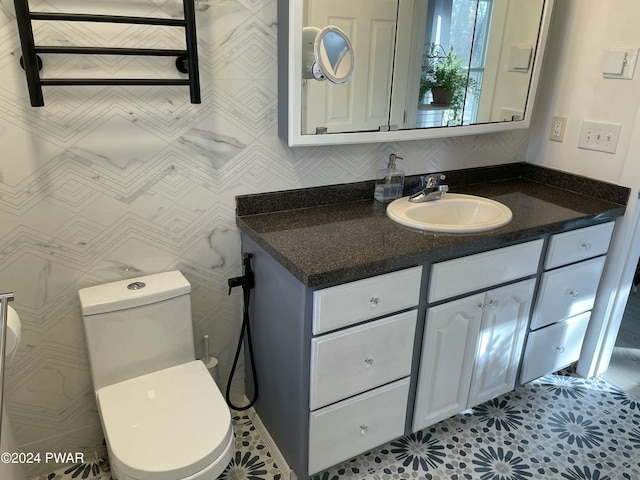 bathroom with toilet, vanity, and tile patterned floors