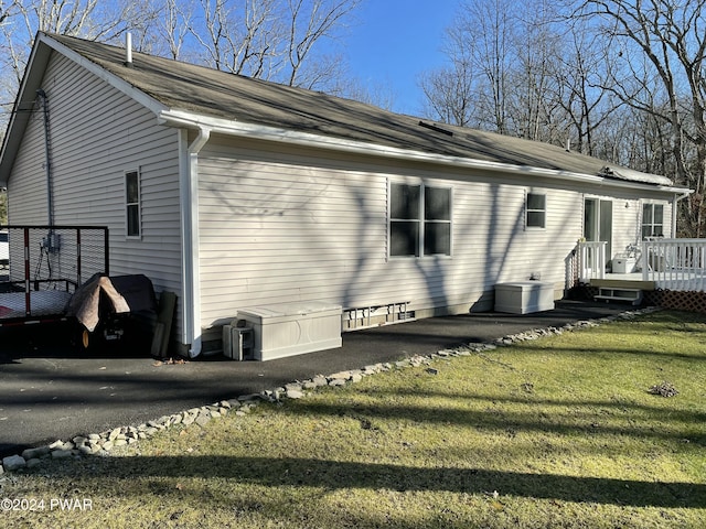 view of side of property featuring a wooden deck and a yard