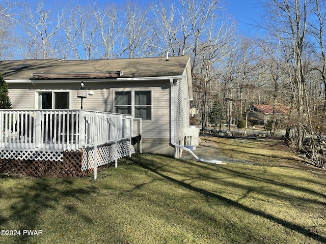 view of home's exterior featuring a deck and a lawn