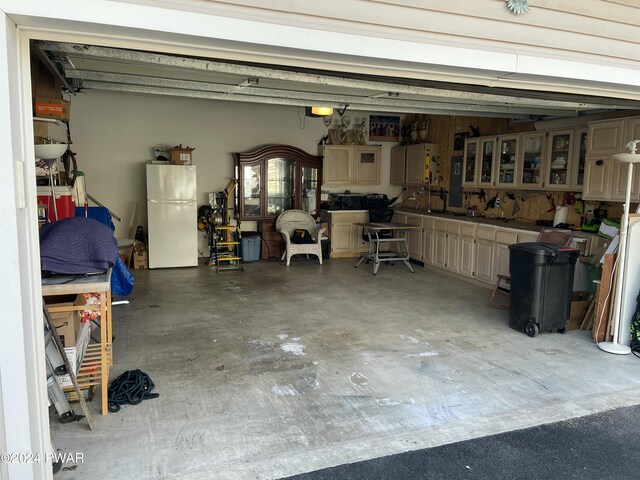 garage featuring a workshop area and white fridge