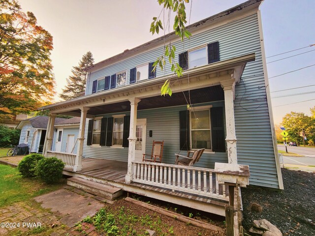 back house at dusk with covered porch