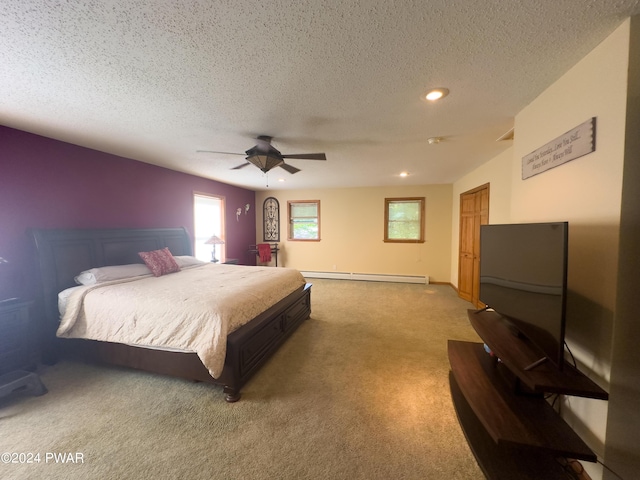 carpeted bedroom with a textured ceiling, ceiling fan, and a baseboard heating unit