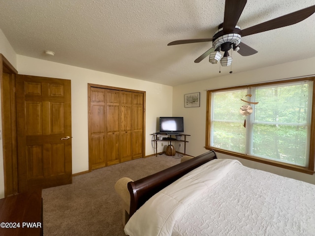 bedroom with carpet flooring, a textured ceiling, and ceiling fan