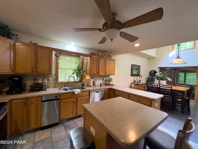 kitchen with dishwasher, a center island, sink, a wealth of natural light, and decorative light fixtures