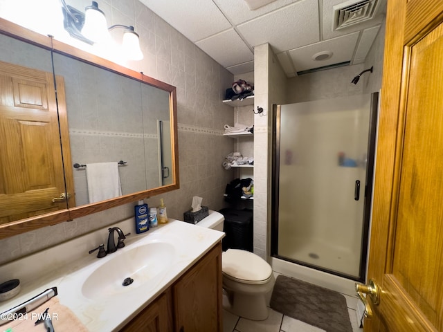 bathroom with walk in shower, vanity, tile patterned flooring, and tile walls