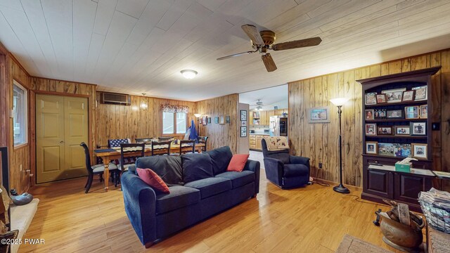 163 Wild Acres Dr, Dingmans Ferry, PA 18328 - living area with wooden walls, a ceiling fan, a wall mounted air conditioner, and light wood-style floors