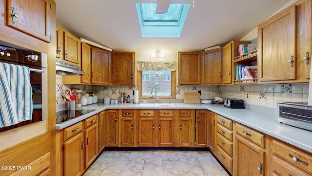163 Wild Acres Dr, Dingmans Ferry, PA 18328 - kitchen with a sink, black electric stovetop, under cabinet range hood, a skylight, and oven