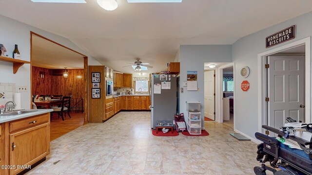 163 Wild Acres Dr, Dingmans Ferry, PA 18328 - kitchen with a sink, freestanding refrigerator, light countertops, brown cabinets, and a ceiling fan