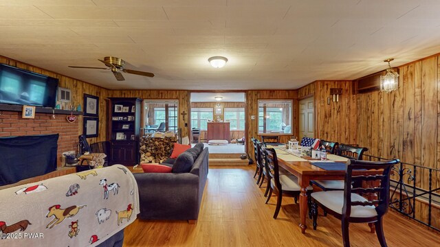 163 Wild Acres Dr, Dingmans Ferry, PA 18328 - dining room with wood walls, wood finished floors, plenty of natural light, a brick fireplace, and ceiling fan