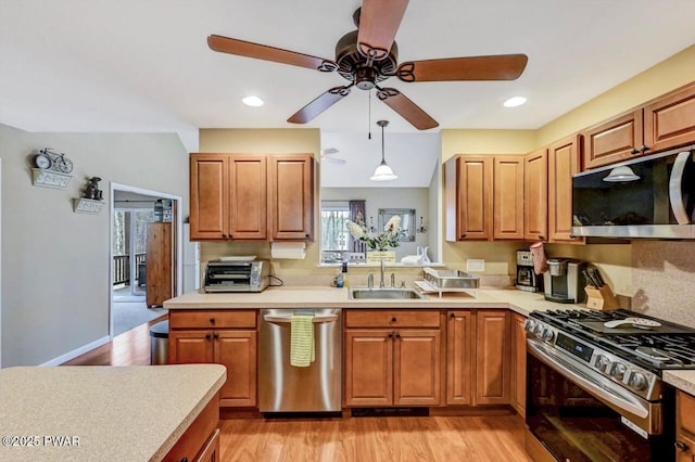 102 Oriole Pl, Lackawaxen, PA 18435 - kitchen featuring appliances with stainless steel finishes, light countertops, light wood-style floors, ceiling fan, and a sink