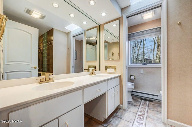 bathroom featuring tile patterned floors, vanity, toilet, and a baseboard radiator