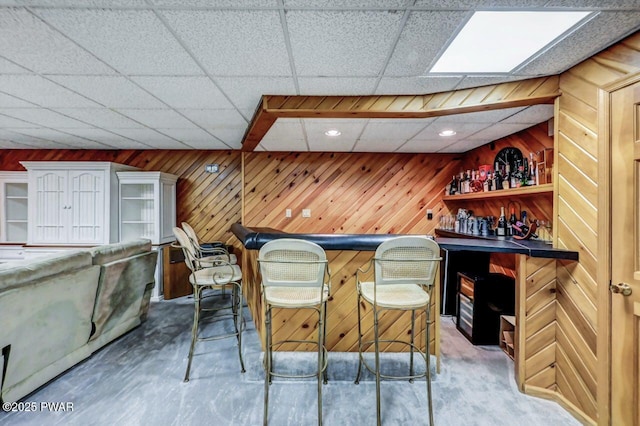 bar with a drop ceiling and wooden walls