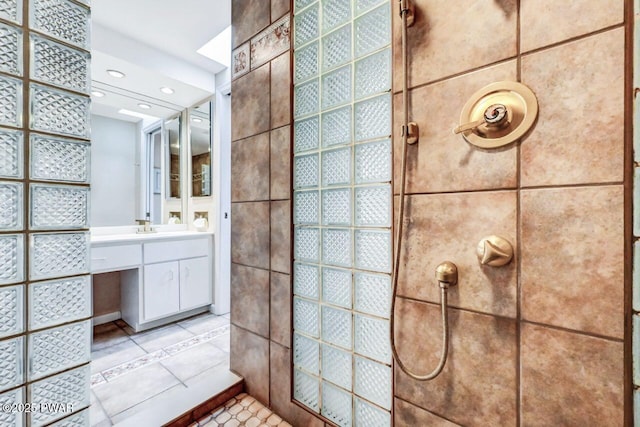 bathroom with tile patterned floors, vanity, tile walls, and walk in shower