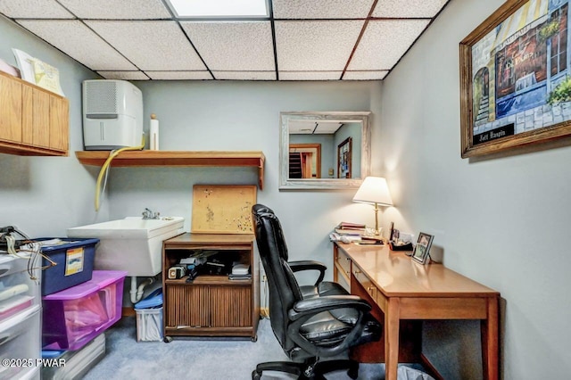 office featuring a paneled ceiling, light colored carpet, and sink