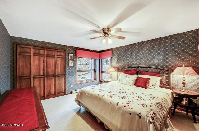 carpeted bedroom featuring baseboard heating and ceiling fan