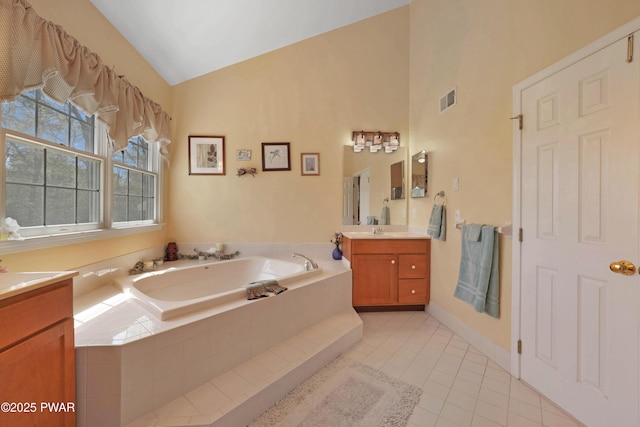 bathroom with vanity, high vaulted ceiling, tile patterned floors, visible vents, and a garden tub
