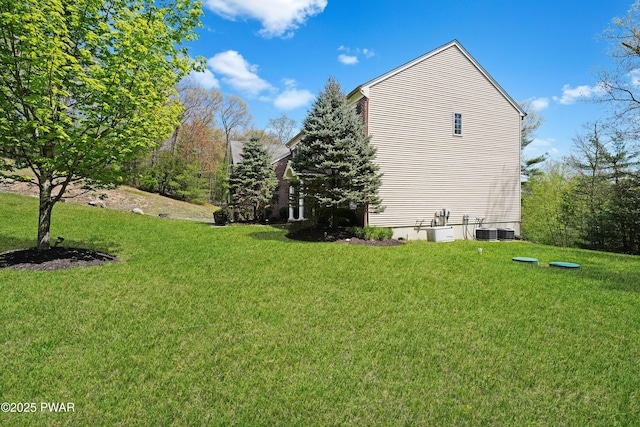view of side of property featuring a lawn and cooling unit