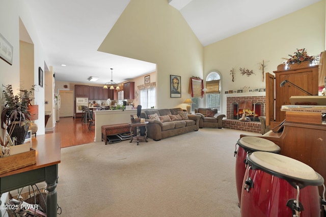 living area featuring a chandelier, lofted ceiling, carpet, and a fireplace