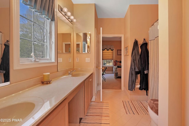 full bath with double vanity, a sink, and tile patterned flooring