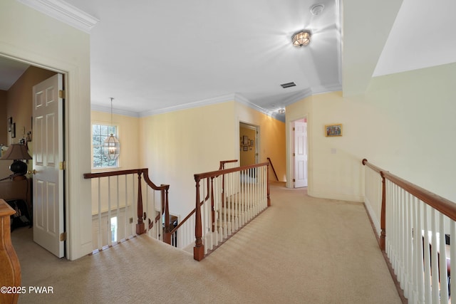 hall with crown molding, carpet flooring, and an upstairs landing