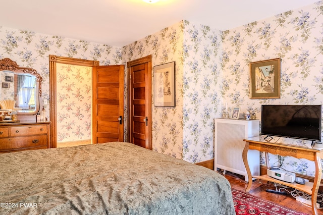 bedroom with dark hardwood / wood-style flooring