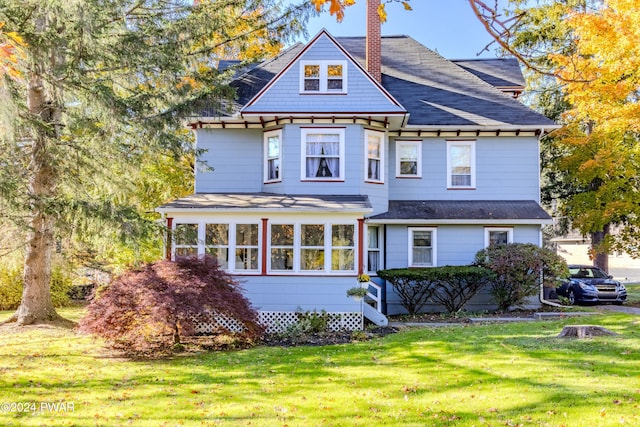 view of front of house with a front lawn and a sunroom