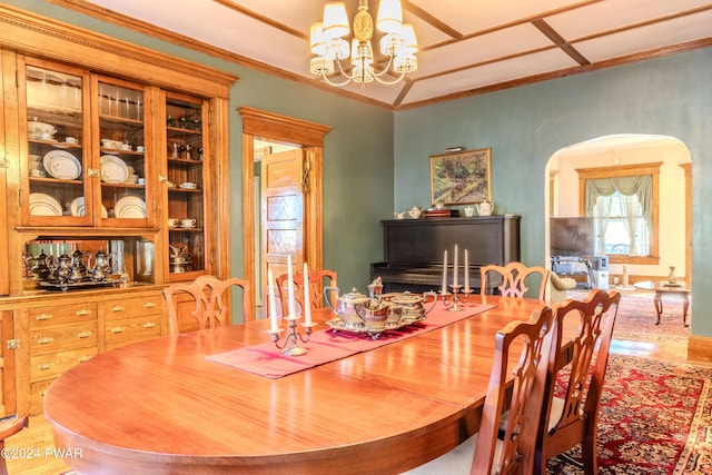 dining room with ornamental molding and an inviting chandelier