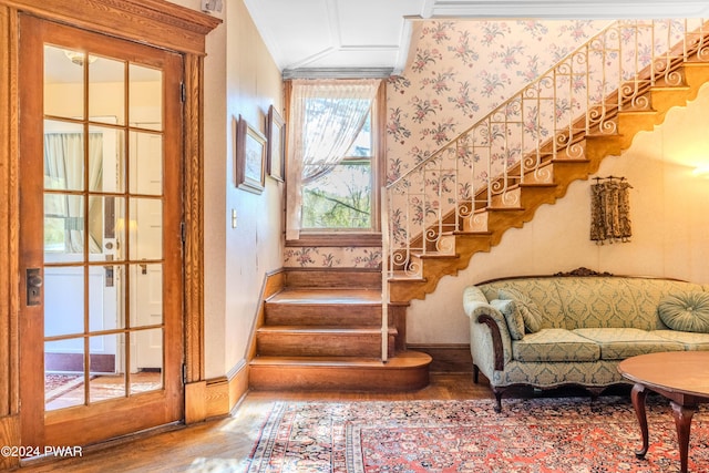 stairs with wood-type flooring and ornamental molding