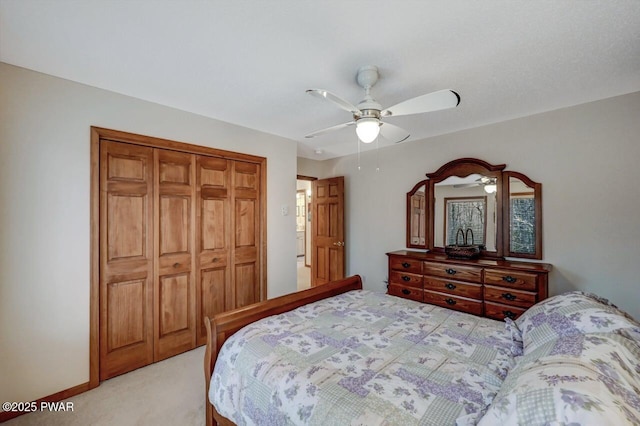 bedroom featuring a closet, baseboards, light colored carpet, and ceiling fan