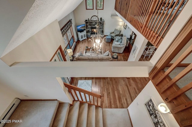 staircase featuring wood finished floors, lofted ceiling, and a baseboard radiator