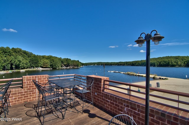 wooden deck with a view of trees and a water view