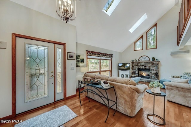 living area featuring high vaulted ceiling, a notable chandelier, wood finished floors, a skylight, and a fireplace