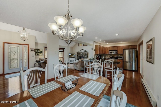 dining room featuring a stone fireplace, an inviting chandelier, dark wood-type flooring, and baseboard heating