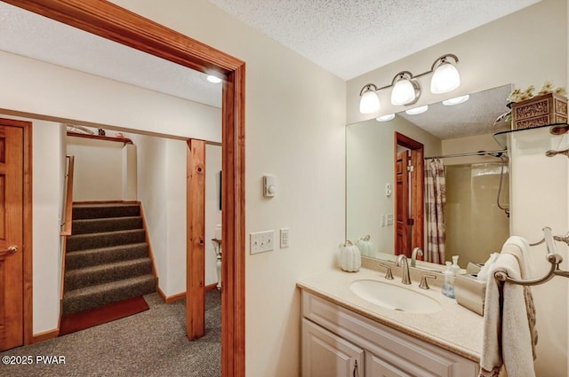 bathroom featuring baseboards, a textured ceiling, vanity, and a shower with curtain