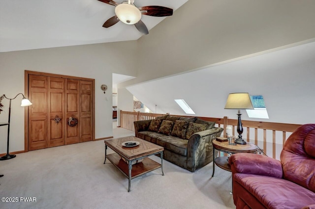 living area featuring light carpet, baseboards, a skylight, and ceiling fan