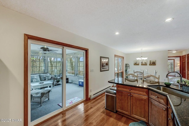 kitchen with a healthy amount of sunlight, a baseboard heating unit, and a sink