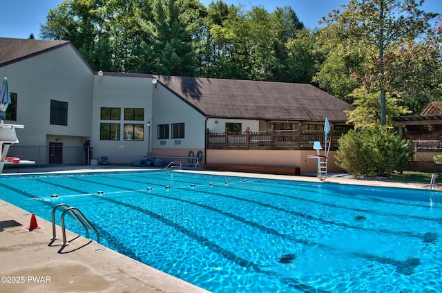 community pool with a patio area and fence