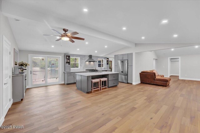 105 Cherry Point Ct, Hawley, PA 18428 - kitchen with gray cabinets, high end fridge, wall chimney exhaust hood, open floor plan, and light countertops