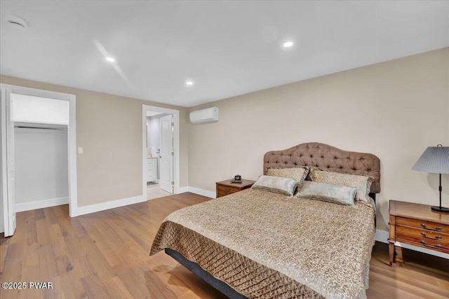 105 Cherry Point Ct, Hawley, PA 18428 - bedroom featuring a wall unit AC, baseboards, wood finished floors, recessed lighting, and ensuite bathroom