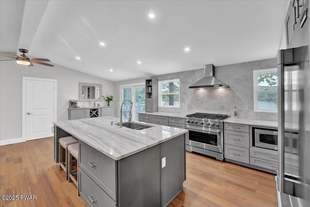 105 Cherry Point Ct, Hawley, PA 18428 - kitchen featuring gray cabinetry, stainless steel appliances, a sink, wall chimney range hood, and vaulted ceiling